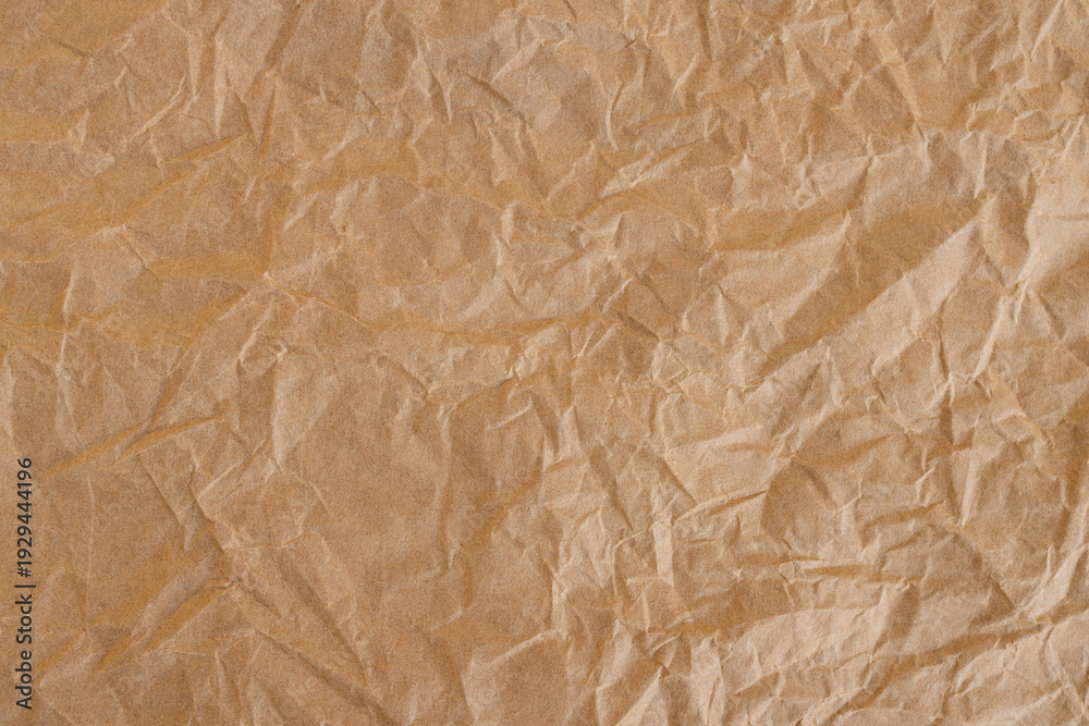 Fototapeta premium Crumpled Brown Kraft Paper Texture Background,Top view of brown crumpled recycled kraft paper texture. Abstract wrinkled paper background with rough creases and shadows, perfect for organic,