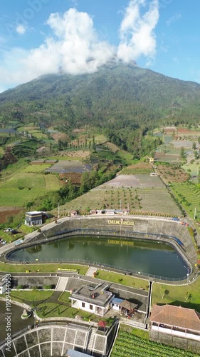 Aerial View of Mountain Terraced Farmland and Reservoir Near Village on a Clear Sunny Day