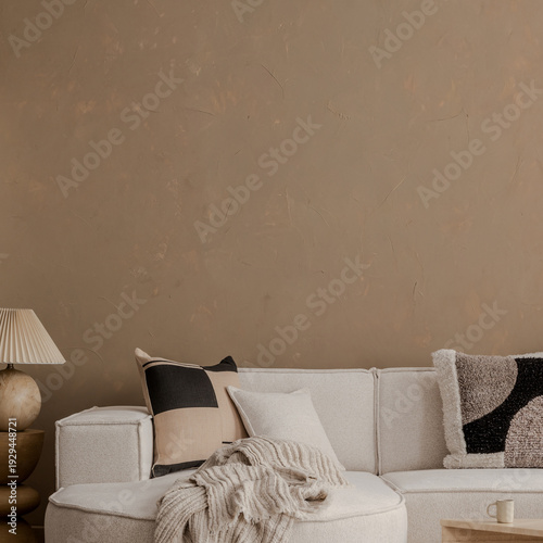 Minimalist living room interior design with light sofa, decorative pillows, cozy blanket, wooden lamp, and brown wall