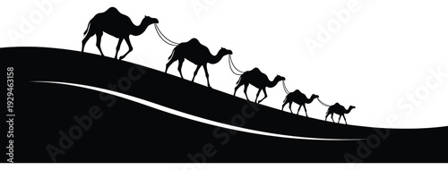 Camels trekking in desert landscape with silhouetted dunes