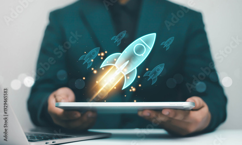 Cuadro en lienzo Startup rocket launch hologram rising from tablet in businessman hands, symbolizing business growth, innovation strategy, digital transformation, project success and technology development concept