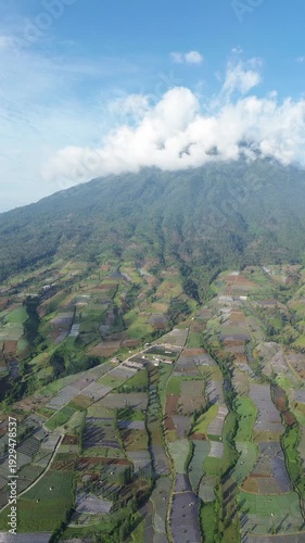 Aerial View of Mountain Terraced Farmland and Reservoir Near Village on a Clear Sunny Day