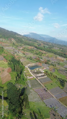 Aerial View of Mountain Terraced Farmland and Reservoir Near Village on a Clear Sunny Day