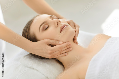 Foto Facial and neck massage for woman in spa and cosmetologists clinic