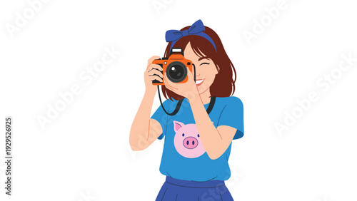 Smiling young woman with a blue headband enjoys her hobby of photography while taking a picture with her camera.
