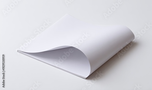 Crisp, white paper pages; top page curled, revealing the layered sheets. Studio, clean lighting