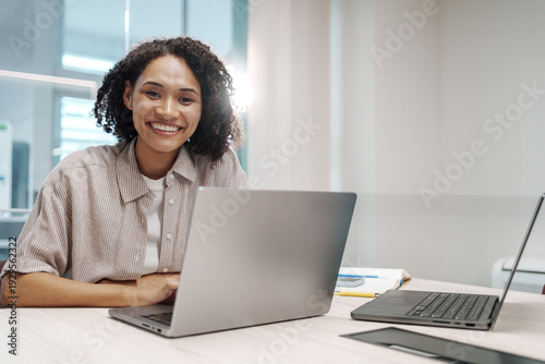 Dedicated Female Employee Engaging With Clients Smoothly Through Chat And Calls In Bright Office Setting