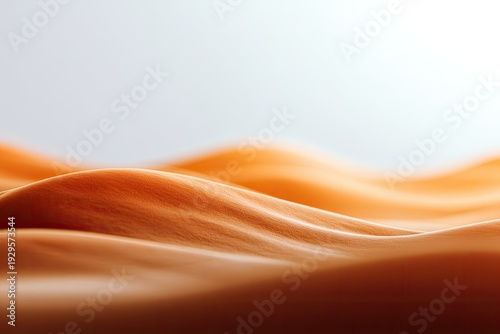 Abstract blurred image of orange fabric waves against a white, softly lit background