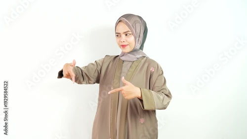 Indonesian Muslim Woman Use Headscarf With Happy Expression and Pointing Down Gesture Isolated on White Background in 4k Resolution. Portrait of Woman Wearing Khimar with Neutral Expression