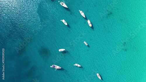 Aerial top view of sailboats and yachts anchored in turquoise Adriatic Sea near Croatia. Clear blue water, summer travel destination and peaceful nautical scene.