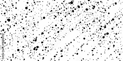 Abstract splatter pattern with varying sizes of black ink dots on white
