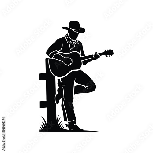 Cowboy with hat playing acoustic guitar leaning on wooden fence in a country outdoor setting