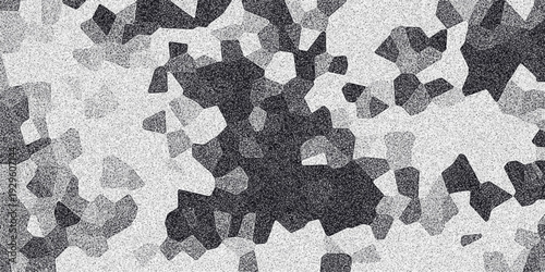 Textured monochrome abstract background with a tessellated pattern of dark and light irregular polygons and a fine grainy overlay for visual depth