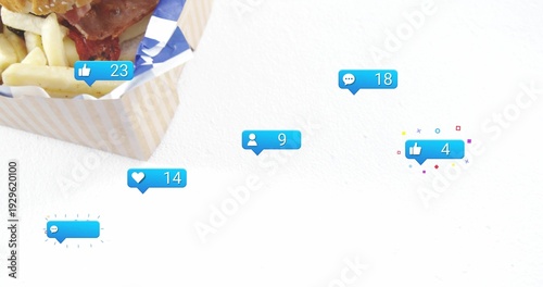 Showing takeout box holding sesame burger and fries on white studio, with blue bubbles, copy space