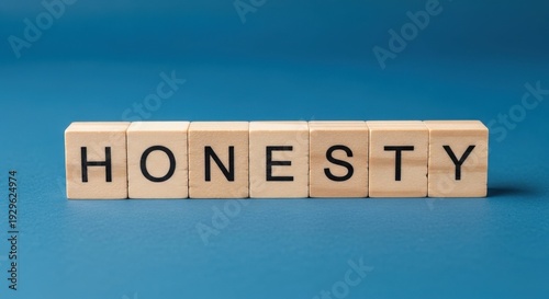 Wooden blocks spelling out the concept of honesty on a blue background