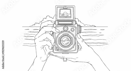 Hands hold a vintage camera, framing a seascape with clouds
