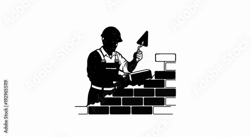 Silhouette of a bricklayer in hard hat applying mortar to a brick wall