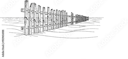 A weathered wooden fence stretches across a sandy expanse under a clear sky