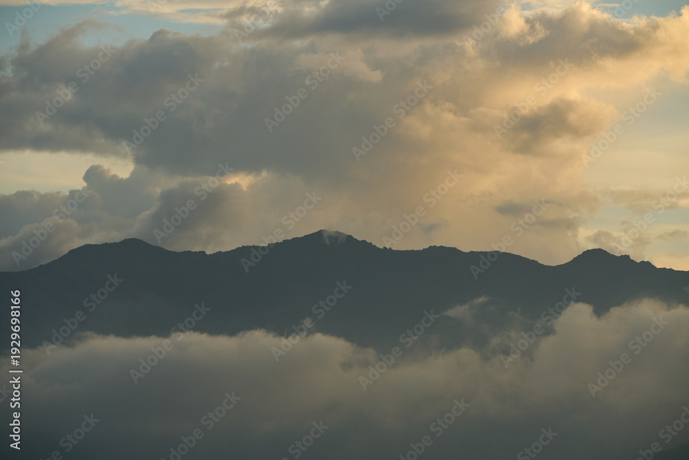 Obraz premium Beautiful sunset over the mountains with huge clouds.