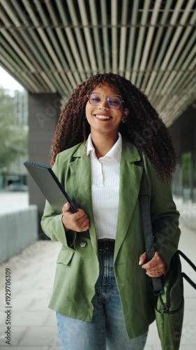 Confident African American business woman walking in office. Portrait of smiling female executive enjoying successful corporate career