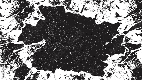 Grunge black paint splash on white background with textured rough edges and scattered speckles
