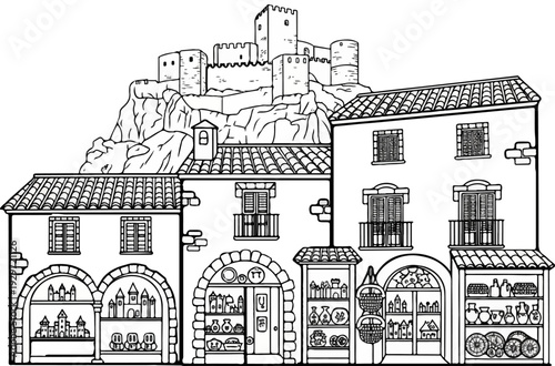 Medieval castle overlooks a quaint European village with shops displaying ceramics and crafts