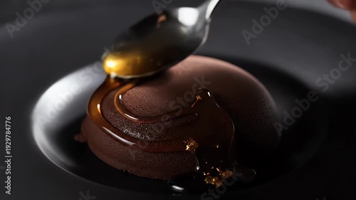 Chocolate Dome Dessert Drizzled with Golden Syrup on Black Plate