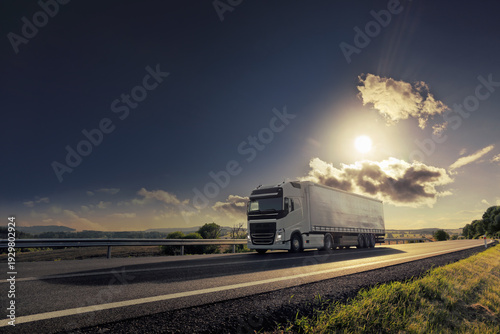 Foto A trucks on a highway at sunset drives through a wide landscape, transporting go