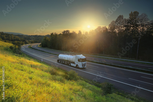 Foto A trucks on a highway at sunset drives through a wide landscape, transporting go