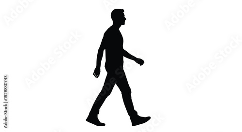 A solitary man is captured in mid stride walking forward with a relaxed posture presented as a striking silhouette