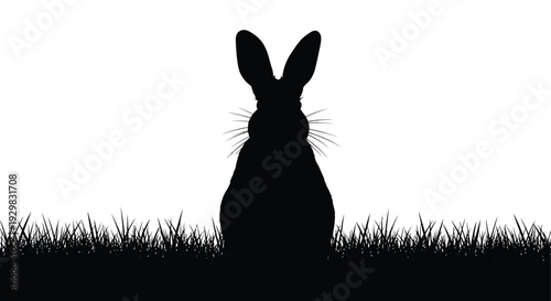A striking black silhouette of a rabbit sitting amidst tall blades of grass presented against a bright white background silhouette