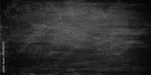 A blank vintage blackboard with a dark grunge texture and a scratched aged surface provides a black chalkboard background for an old concrete wall design backdrop