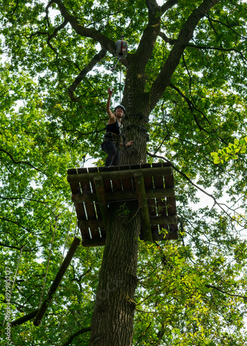 Happy woman celebrating success on high ropes course platform