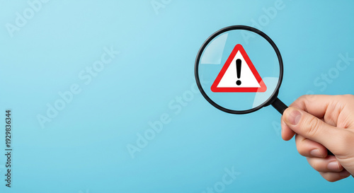 Free Download A hand holding a magnifying glass over a red warning triangle, perfect for risk assessment concepts and error detection plans - GFXLoad