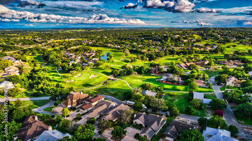 Aerial View of a Luxury Suburban Golf Course Neighborhood Under a Dramatic Clouded Sky