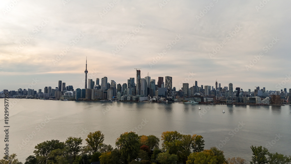 Fototapeta premium Stunning view of Toronto city skyline with lake and trees in foreground, Canada