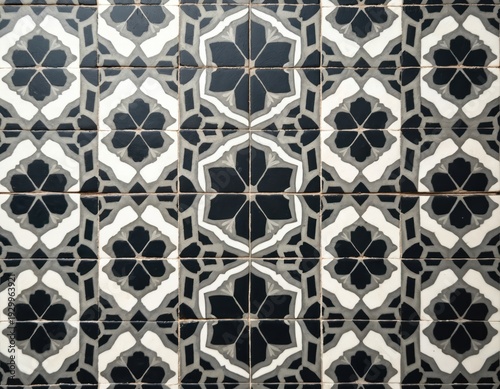 Intricate geometric zellige tile pattern, black and white floral motifs repeat. This Moroccan design decorates surfaces like walls and floors.