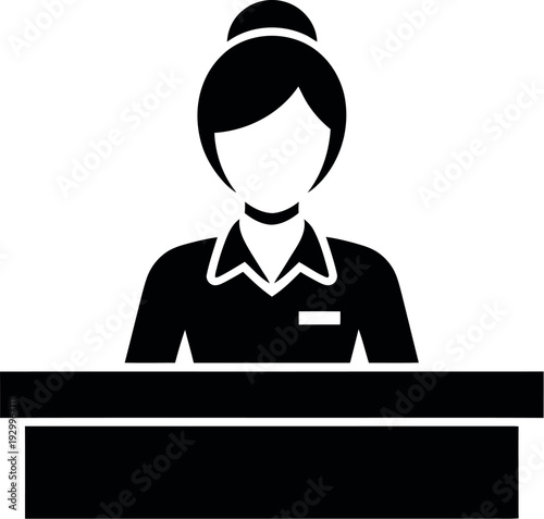 A female receptionist wearing a uniform and standing behind a desk with a friendly smile