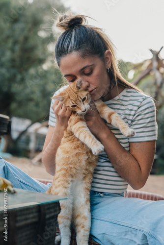 Konstfotografi Woman hugging ginger cat showing pet affection