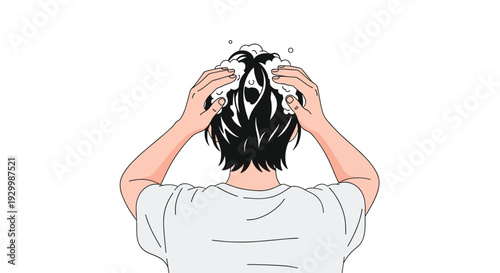 A person viewed from behind with short black hair uses both hands to massage white soapy lather into their scalp while wearing a grey shirt.