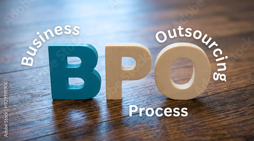 Wooden letters BPO with Business Outsourcing Process text on a rich dark wood table for corporate st