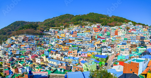 Panoramic view of colorful hillside houses at Gamcheon Culture Village overlooking Busan city and coastline, showcasing vibrant urban landscape and cultural tourism destination in South Korea.