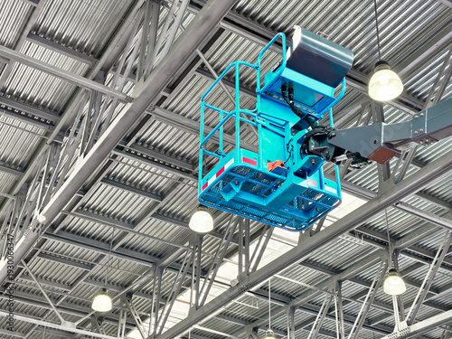 Construction crew using aerial lift to inspect high ceilings in a large warehouse during daytime work hours