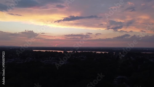 Short video flying from left to right, with a drone, way above the city at sundown