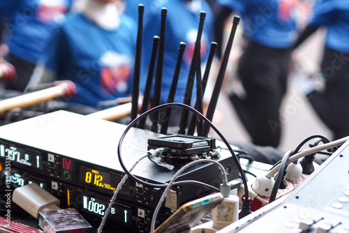 professional audio engineering setup, likely at an outdoor event or concert, given the blurred figures in the background.