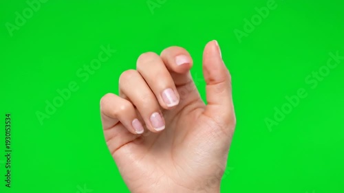 A hand gesture captured in a close-up VIDEO shot against a vibrant green background from a straightforward viewpoint