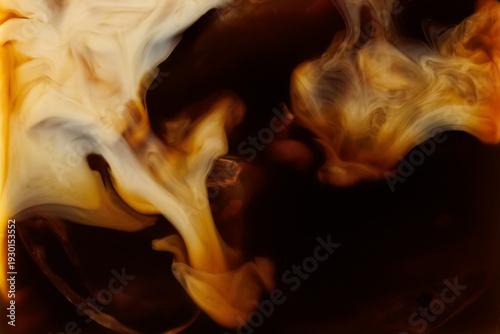 Macro shot of milk mixing into coffee with ice