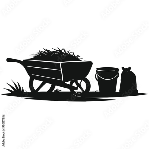 Silhouette of wheelbarrow with garden tools and grass