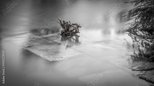 High resolution black and white image Stillness in Motion – Black and White Long Exposure Fine Art Print- Long exposure river with rocks and a big log of wood