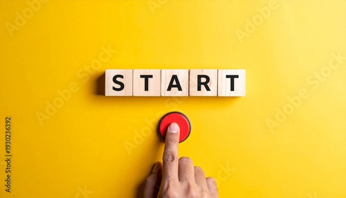 Hand pressing red button below blocks spelling START on yellow background